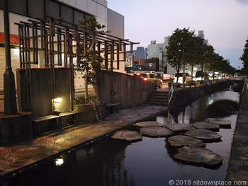 星川の石畳近くにあるライトアップされた木製ベンチ